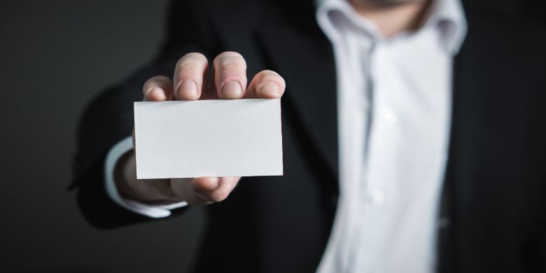 A person presenting a business card or ID card.