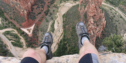 hiker sitting edge of a cliff