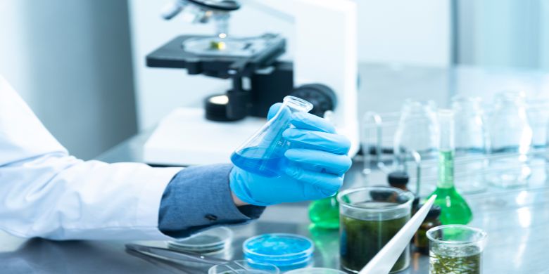 A scientist in a lab coat performing some scientific work.