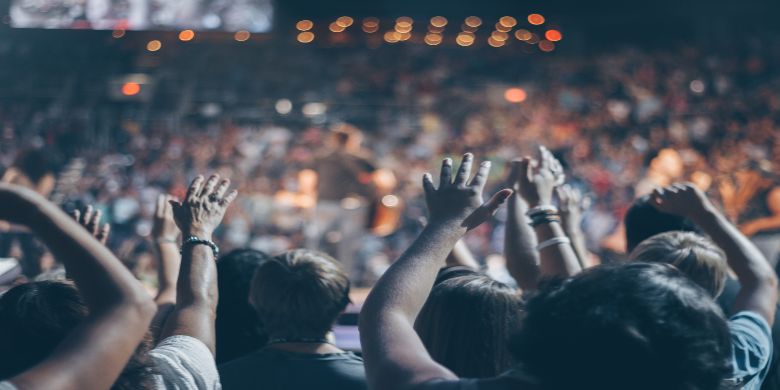 A crowded event with people cheering.