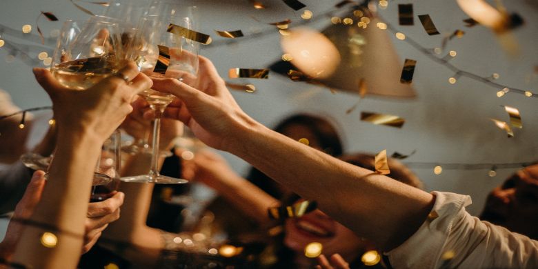 People cheersing with wine glasses.