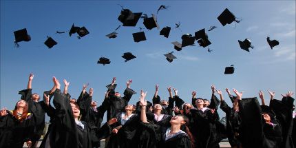 Students throwing their graduation hats into the air.