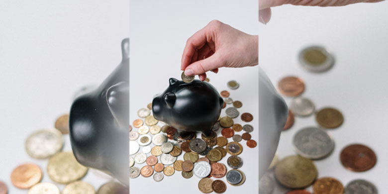 A piggy bank with coins surrounding it.