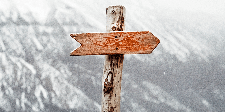 A blank sign post on a baron mountain range