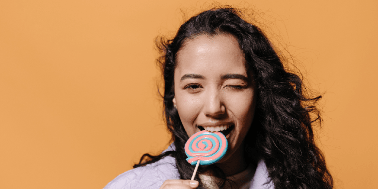 woman biting a lollipop