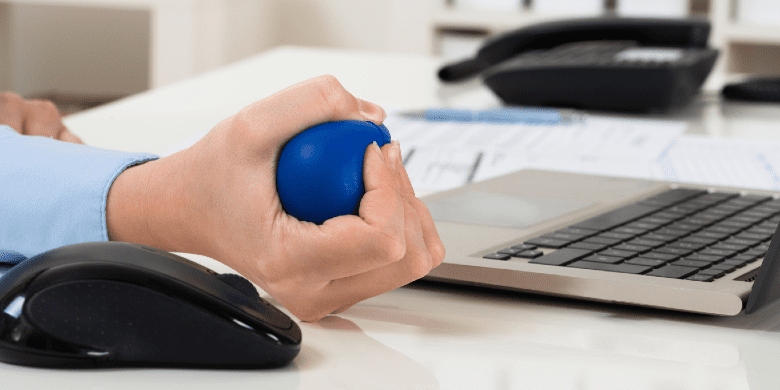 squeezing stress ball at desk