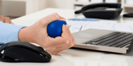 squeezing stress ball at desk