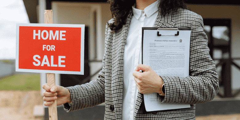 real estate agent holding for sale sign