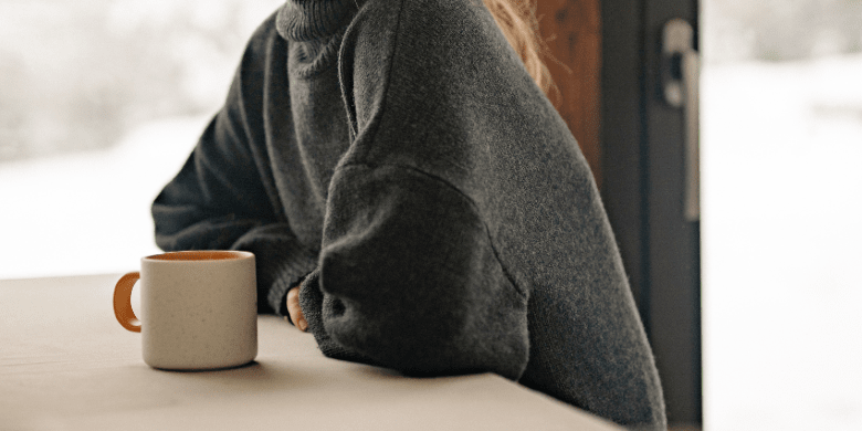 woman sitting in cafe with mug