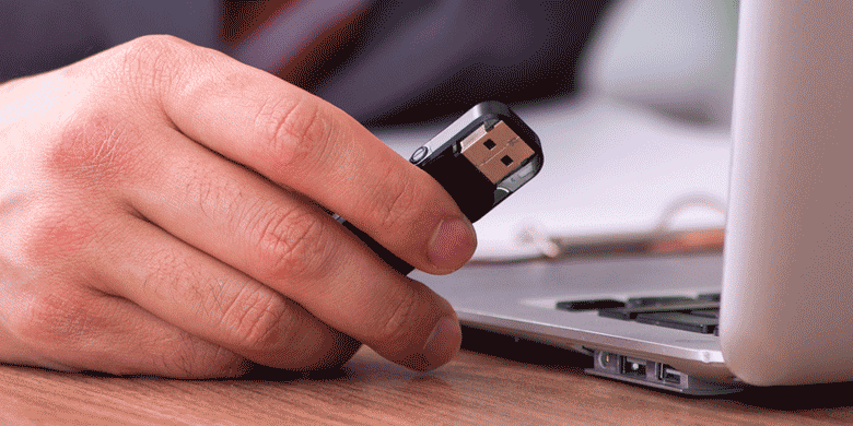 man inserting usb into laptop