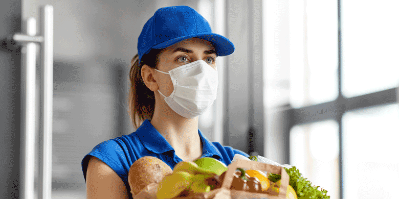 woman wearing face mask delivering groceries 