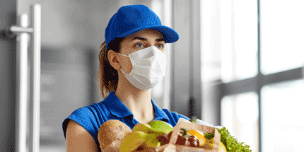 woman wearing face mask delivering groceries 