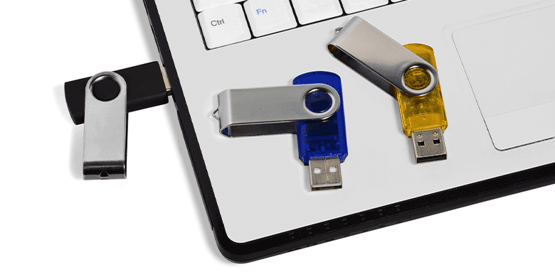 three thumb drives on laptop