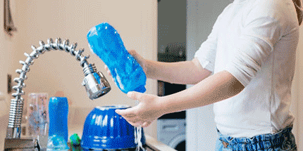 cleaning a drink bottle in sink